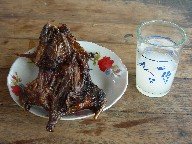 Plate with roast and glass of palm beer